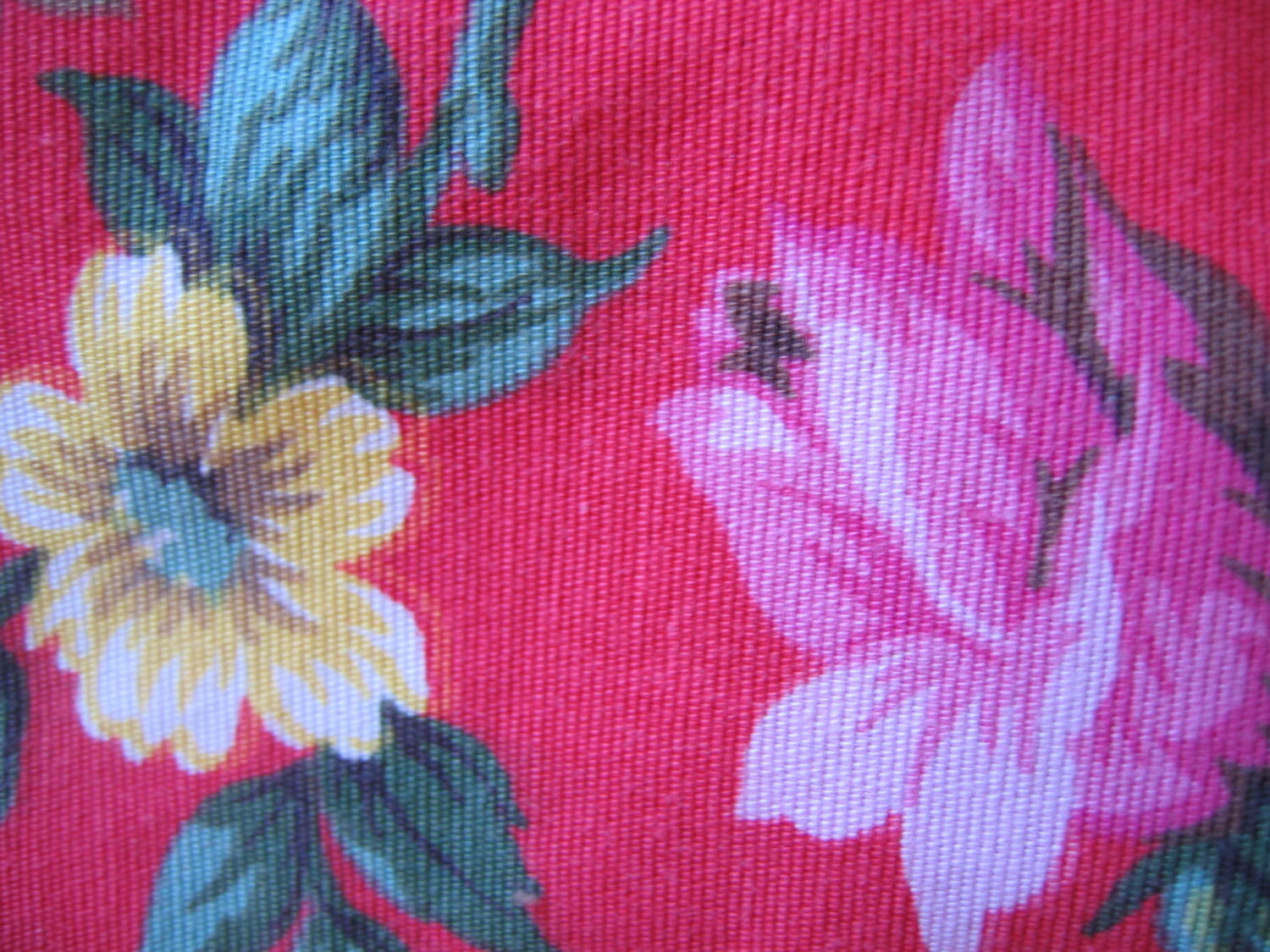 Close up of the red furniture fabric with pink roses and yellow flowers 