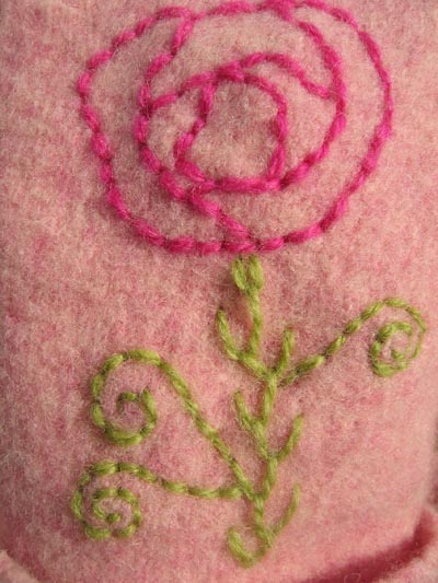 Close up on the embroidered pink rose on wool gloves