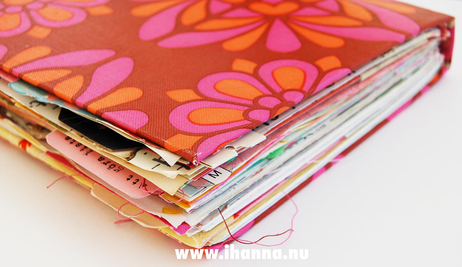 Side view of the edges of a pink and orange hand bound junk journal or art journal by iHanna (copyright Hanna Andersson)