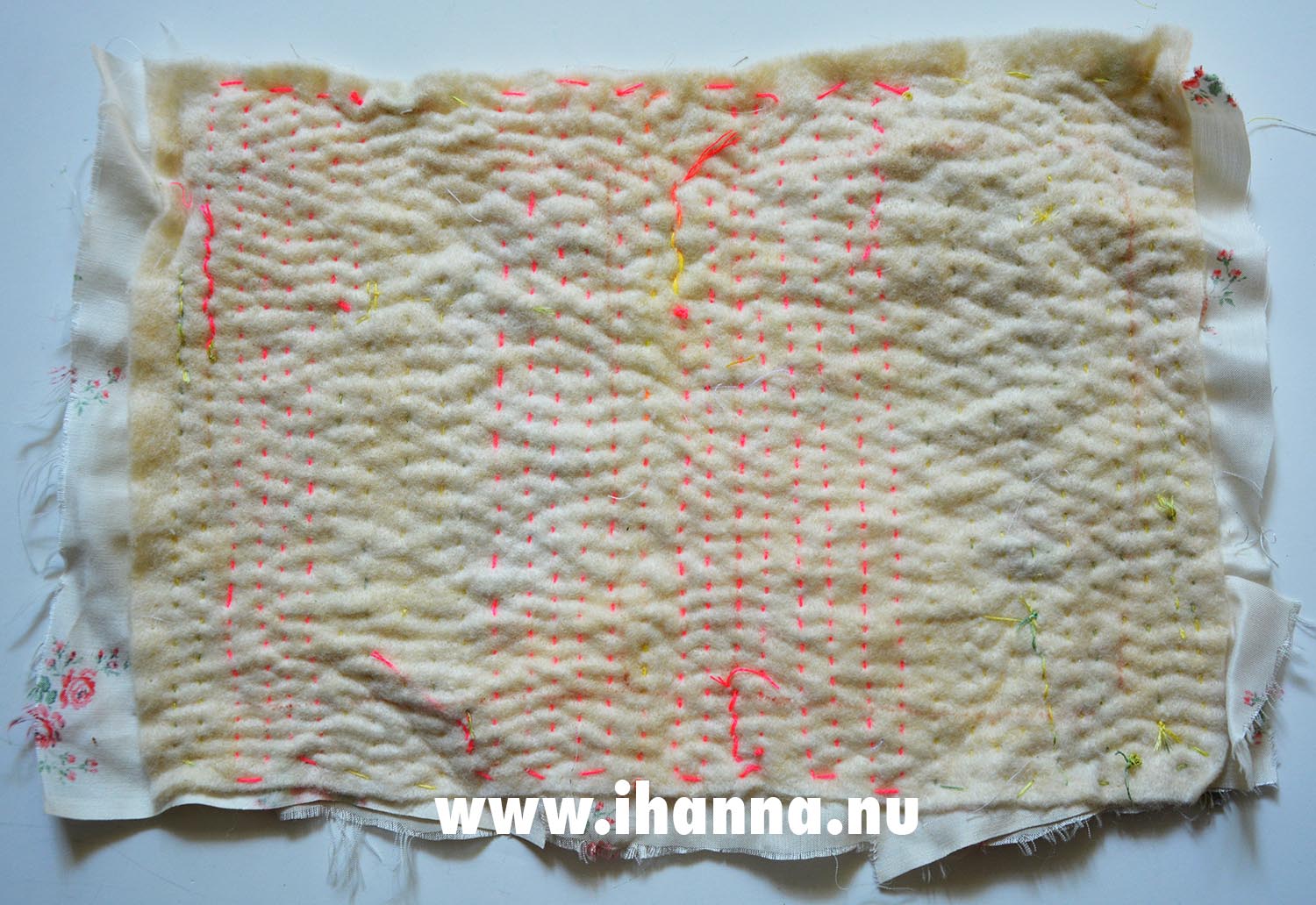 Backside of embroidered boro cloth with neon pink stitches through the wadding  (Copyright Hanna Andersson)