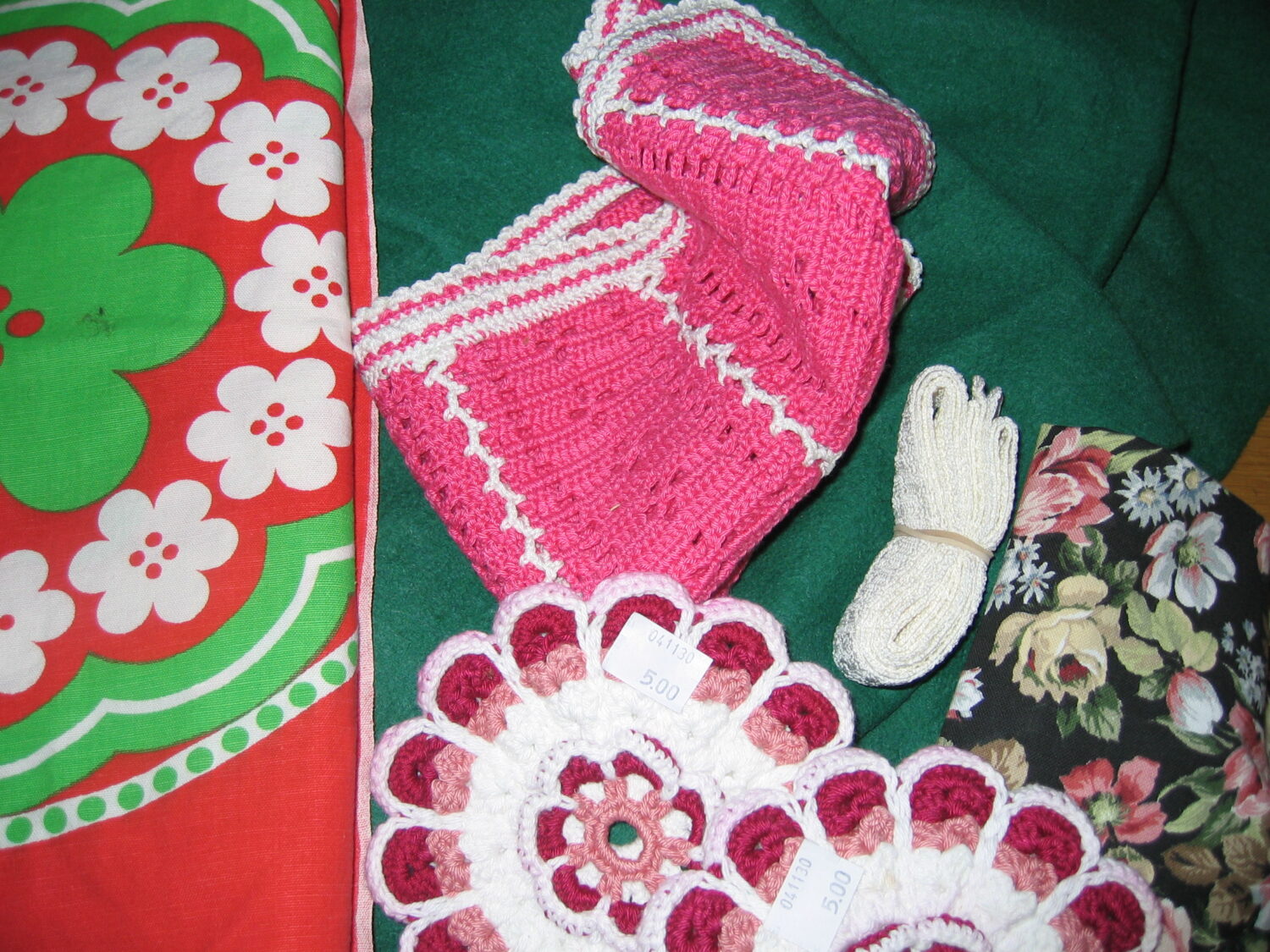 Pile of thrifted fabrics, lace and crocheted pot holders from the second hand store (Copyright Hanna Andersson)