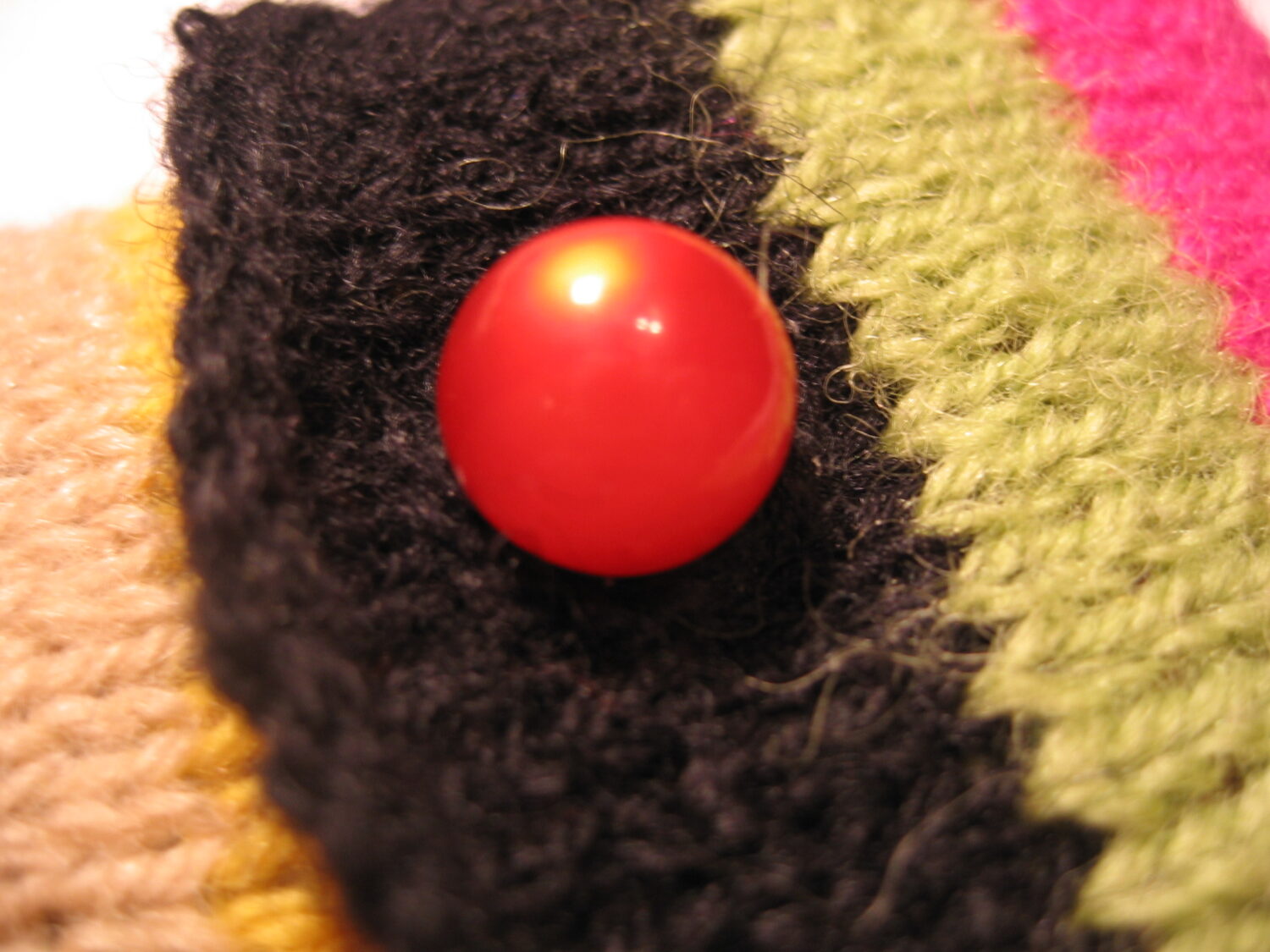 Close up of the button on the knitted cell phone cozy by iHanna (Copyright Hanna Andersson)