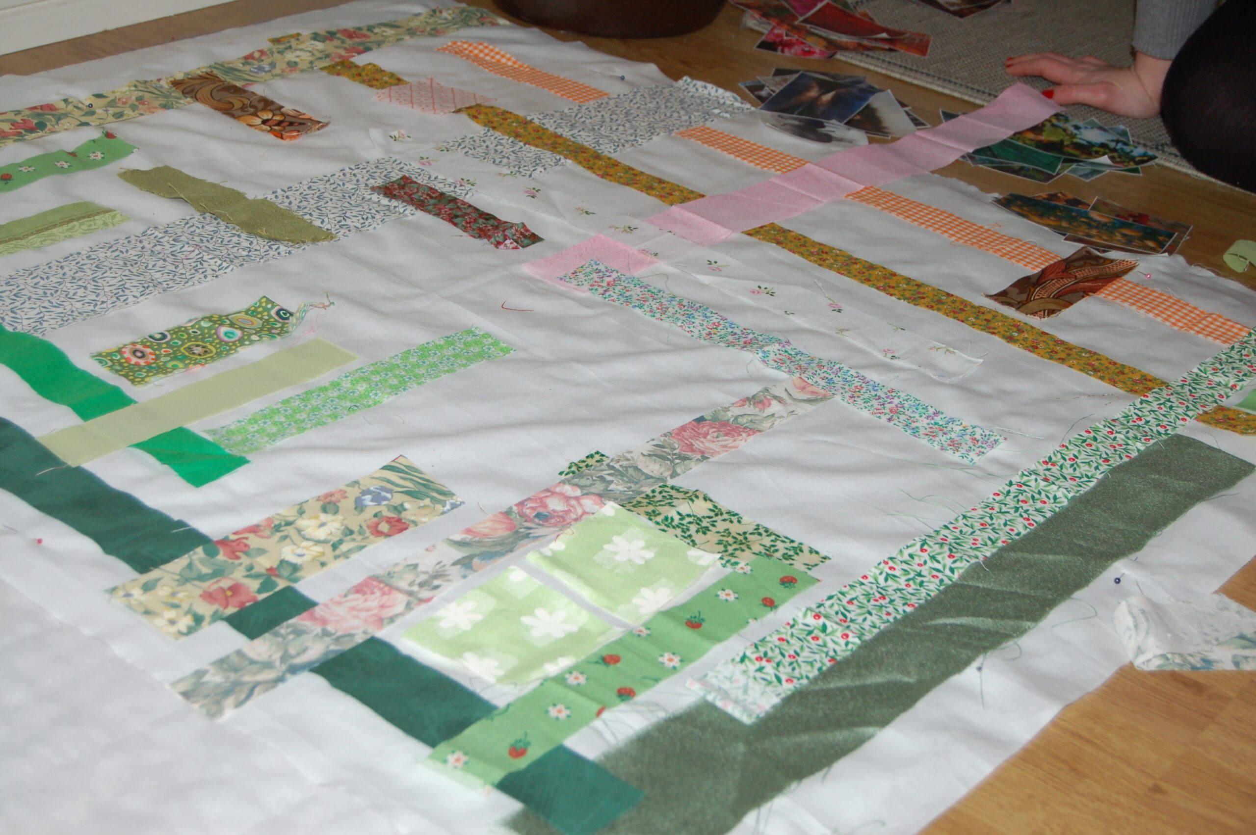 Creating a collage of images and green fabrics for the Photo Quilt of Inspiration (Photo Copyright Hanna Andersson)