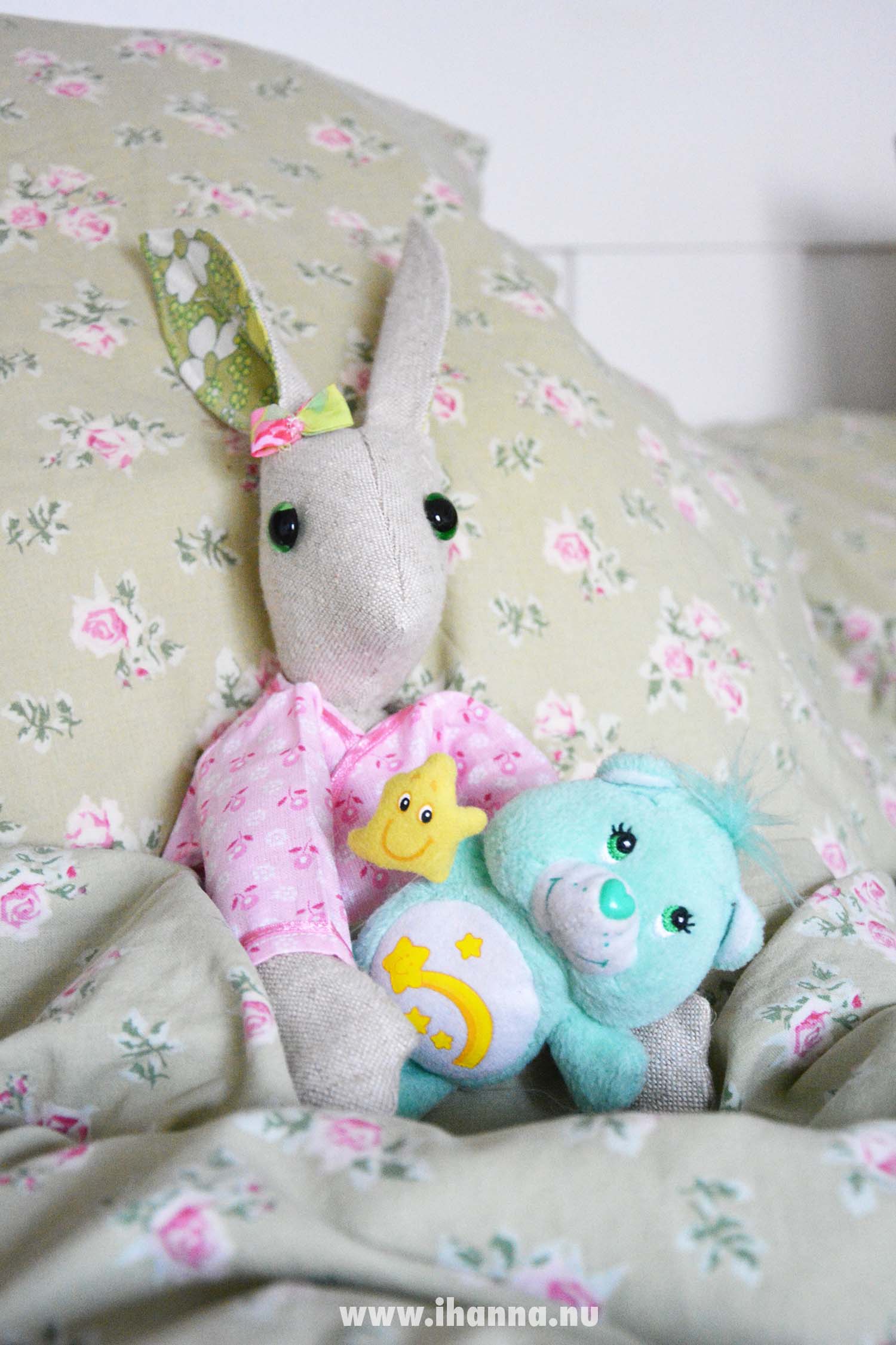 Luna Lapin in pink pyjamas with her Care Bear in bed (Photo copyright Hanna Andersson)